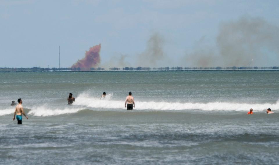 A cloud of orange smoke rises over Cape Canaveral. SpaceX reported an anomaly during test firing of the Dragon 2 in April 2019.