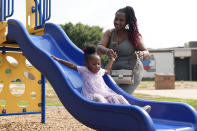 Tamika Davis, right, spends time with her daughter, Shanara, 3, at MLK Park in San Antonio, Thursday, May 30, 2024. Davis said friends and family watched her kids for most of her doctor visits during treatment last year for colon cancer. But she couldn't afford additional childcare, and she didn't know where to look for assistance. (AP Photo/Eric Gay)
