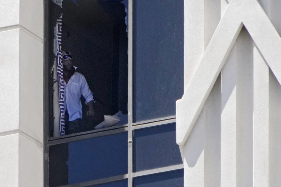 A person looks out a broken window on a hotel tower at Caesars Palace hotel-casino, Tuesday, July 11, 2023, in Las Vegas. (AP Photo/John Locher)