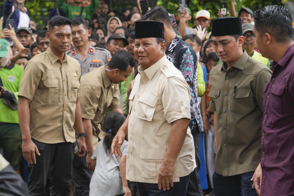 Indonesian Defense Minister and presidential frontrunner Prabowo Subianto, center, arrives for a visit to his father's grave in Jakarta, Indonesia Thursday, Feb. 15, 2024. The wealthy ex-general looks set to be the country's next president after unofficial tallies showed him taking a clear majority in the first round of voting. (AP Photo/Tatan Syuflana)