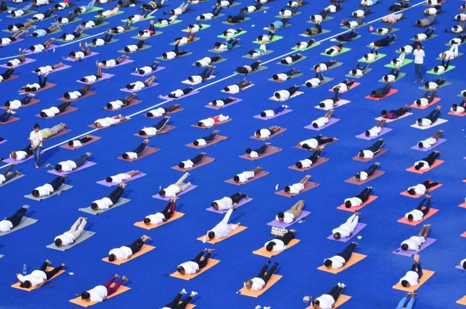 People perform yoga during the International Yoga Day at Kalinga Stadium in India on 21 June 2024 (REUTERS)