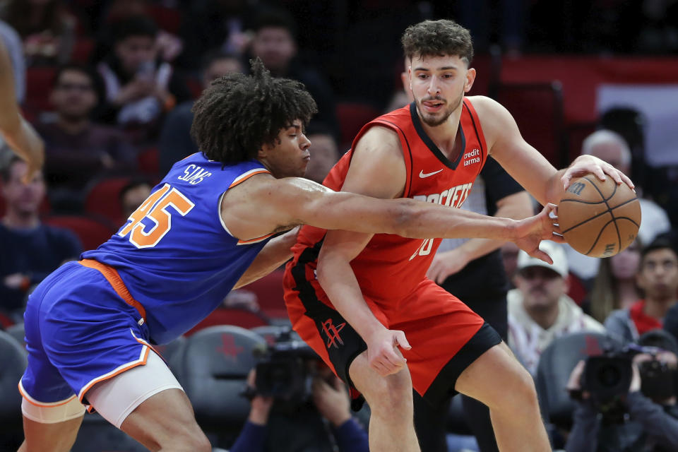 New York Knicks center Jericho Sims, left, knocks the ball away as Houston Rockets center Alperen Sengun, right, drives toward the basket during the first half of an NBA basketball game Monday, Feb. 12, 2024, in Houston. (AP Photo/Michael Wyke)