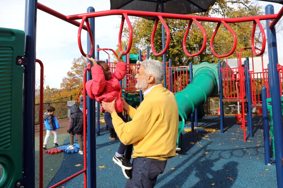 Howard Milbert, executive director of the Ossining Children's Center, helps a pre-k student on the playground Nov. 8, 2023. The center is a not-for-profit organization and will have to do more fundraising as federal pandemic funds run out.