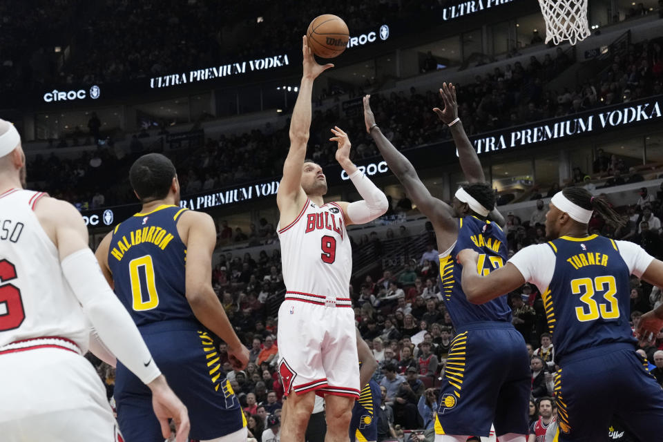 Chicago Bulls center Nikola Vucevic (9) shoots over Indiana Pacers forward Pascal Siakam and center Myles Turner, right, during the first half of an NBA basketball game in Chicago, Wednesday, March 27, 2024. (AP Photo/Nam Y. Huh)