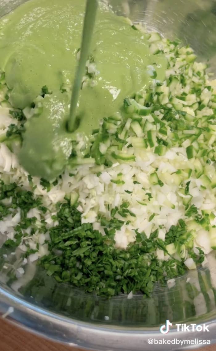 Dressing being poured onto the unmixed salad