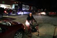 An elderly woman pushes a walking frame past a bus belonging to Democratic 2020 U.S. presidential candidate and former Vice President Joe Biden's campaign in Des Moines