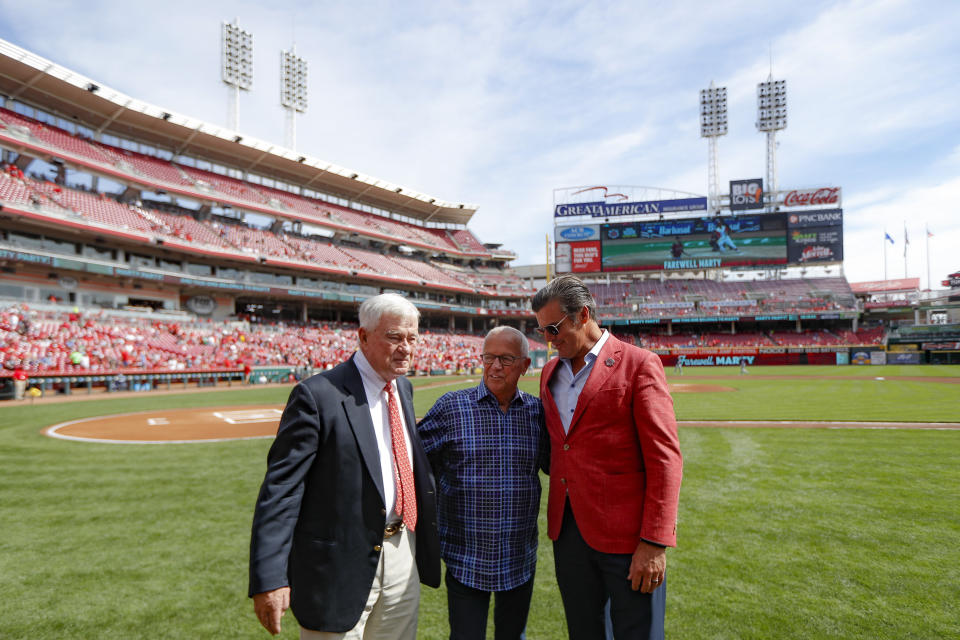 Cincinnati Reds announcer Marty Brennaman, center, stands with Reds owner Bob Castellini, left, and Phil Castellini, right, before a baseball game against the Milwaukee Brewers, Thursday, Sept. 26, 2019, in Cincinnati. The 77-year-old broadcaster is retiring after 46 years. (AP Photo/John Minchillo)