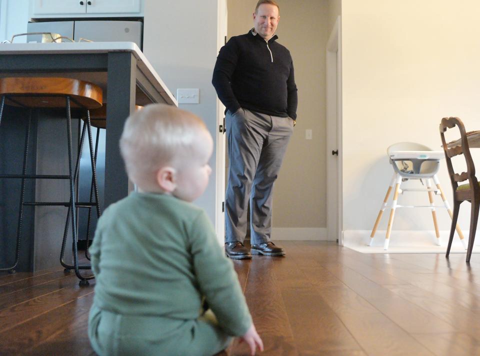 Jon Albert, 47, watches his nine-month-old son Evan at home in Fairview Township on Jan. 25, 2024. Evan was delivered by mother Stephanie Albert, Jon's wife, after an embryonic adoption.