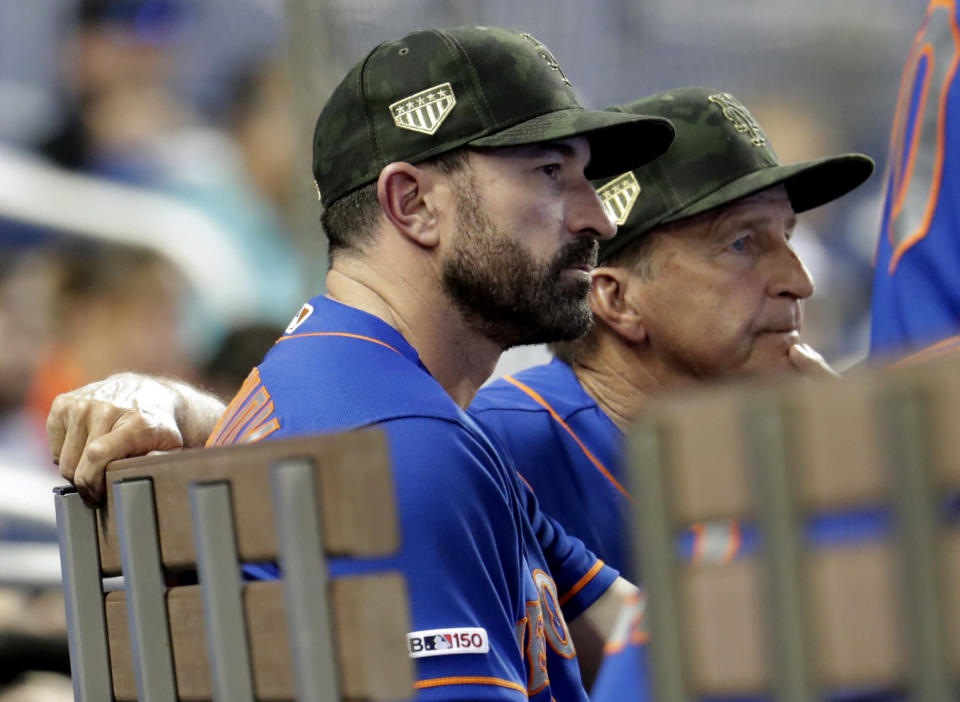 New York Mets manager Mickey Callaway, left, watches in the eighth inning during a baseball game against the Miami Marlins, Sunday, May 19, 2019, in Miami. The Marlins won 3-0. (AP Photo/Lynne Sladky)