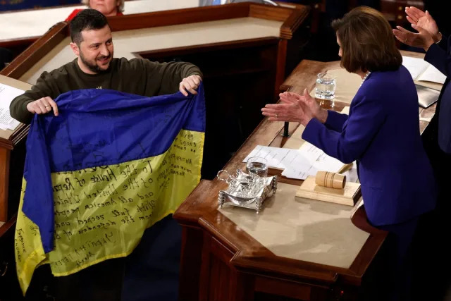 President of Ukraine Volodymyr Zelensky gives a Ukrainian flag signed by members of the Ukrainian military to U.S. Speaker of the House Nancy Pelosi (D-CA) as he addresses a joint meeting of Congress in the House Chamber of the U.S. Capitol on December 21, 2022 in Washington, DC. (Getty Images)