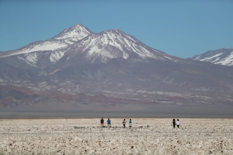 FILE PHOTO: Tourists walk on the Atacama salt flat near Cejar lagoon in the Atacama desert