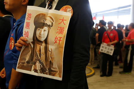 A protester carries a printout depicting legislator-elect Yau Wai-ching as a traitor during a demonstration outside the Legislative Council in Hong Kong, China October 19, 2016. REUTERS/Bobby Yip