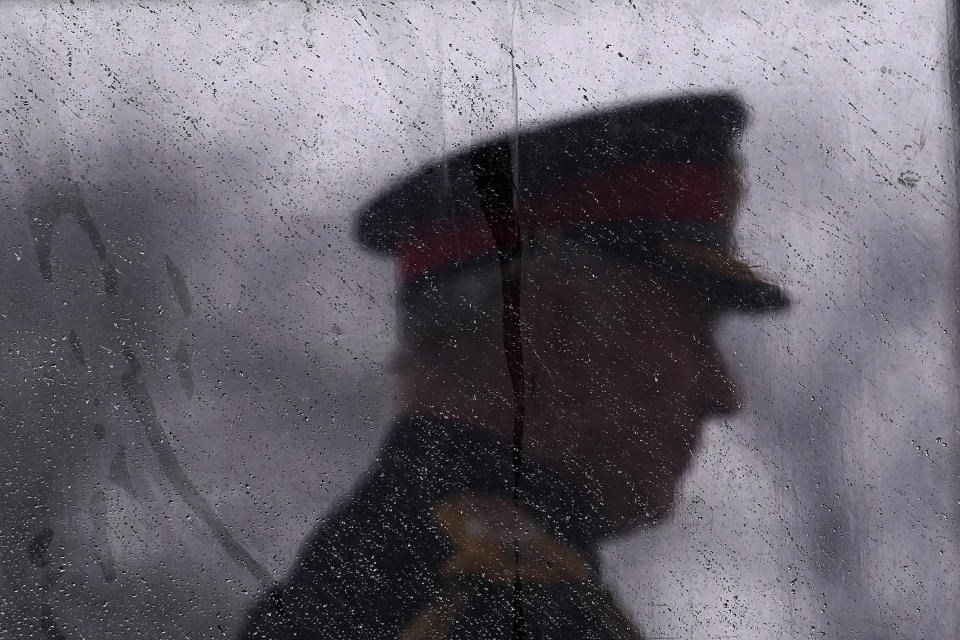 FILE - Britain's King Charles III is silhouetted behind glass covered in raindrops as he inspects the 200th Royal Military Academy Sandhurst's Sovereign's Parade in Camberley, England, Friday, April 14, 2023. The crown has been resized. The troops are prepared for the biggest military procession in 70 years. The Gold State Coach is ready to roll. Now it’s time for the show. King Charles III will be crowned Saturday, May 6, 2023 at Westminster Abbey in an event full of all the pageantry Britain can muster. (AP Photo/Alberto Pezzali, File)