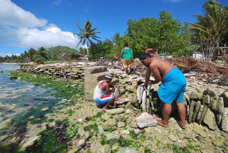 Inhabitants build a stone seawall on Kiritimati coral atoll, where British nuclear tests were conducted more than 56 years ago