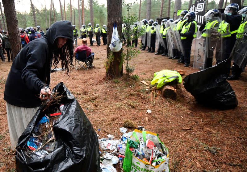 Revellers tidy up rubbish after a suspected illegal rave in Thetford Forest
