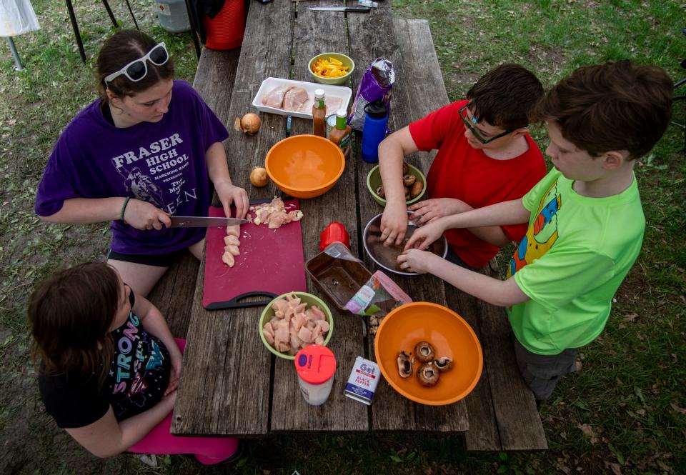 Left to right, Sara White, 10, Uma Ludwig, 14, Logan Pharris, 12, and Simon Osantowske, 11, prepare dinner at D Bar A Scout Ranch in Metamora on Saturday, May 21, 2022. The Troop 1402 camping trip was planned solely by the scouts and the parents sit on standby so scouts can practice planning, cooking, and wilderness skills.