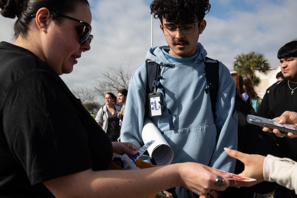 Freshman Rogelio Tabarez watches mother Blanca Tabarez hand out stickers to classmates during a walkout at Gregory-Portland High School on Wednesday, Feb. 21, 2024, in Portland, Texas.