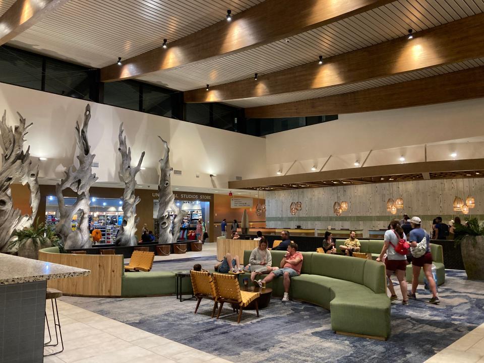 lobby at dockside with green couches on rugged floor with wood beamed ceilings