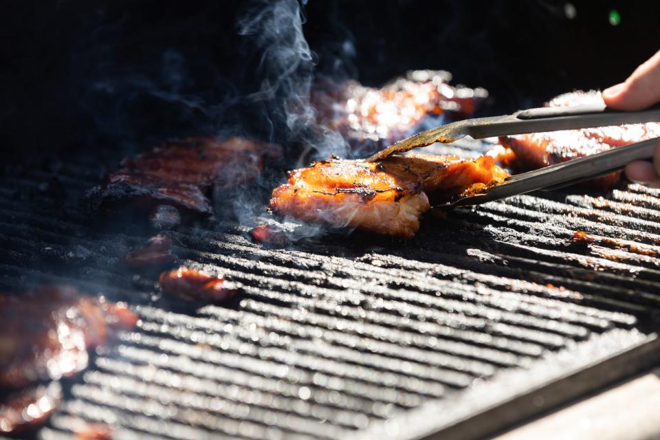 Parker Rasband, 17 from Cedar Hills, cooks meat on the grill for a dinner plate sale where the proceeds will go to aiding Maui at organizer Jenny Wunder’s home in Cedar Hills on Saturday, Aug. 19, 2023. | Megan Nielsen, Deseret News