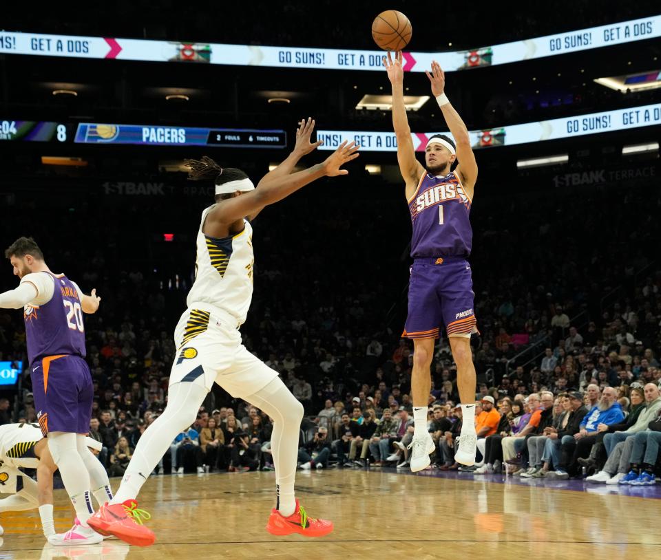 Phoenix Suns guard Devin Booker (1) shoots a three-point basket against Indiana Pacers center Myles Turner (33) during the first quarter at Footprint Center in Phoenix on Jan. 21, 2024.