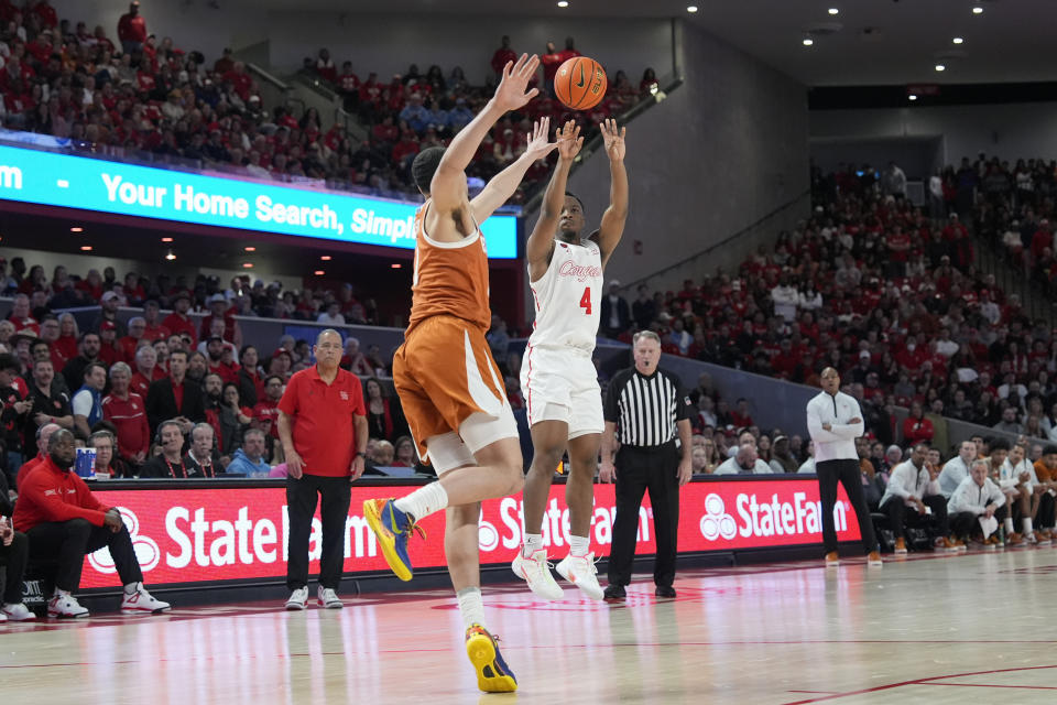 Houston's L.J. Cryer (4) shoots as Texas's Dylan Disu (1) defends during the second half of an NCAA college basketball game Saturday, Feb. 17, 2024, in Houston. Houston won 82-61. (AP Photo/David J. Phillip)
