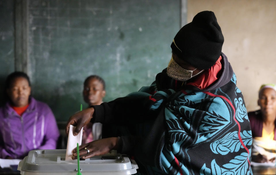 A woman covered with a blanket casts her vote at a poling station in Maseru, Lesotho, Friday, Oct. 7, 2022. Voters across Lesotho are heading to the polls Friday to elect a leader to find solutions to high unemployment and crime. (AP Photo/Themba Hadebe)