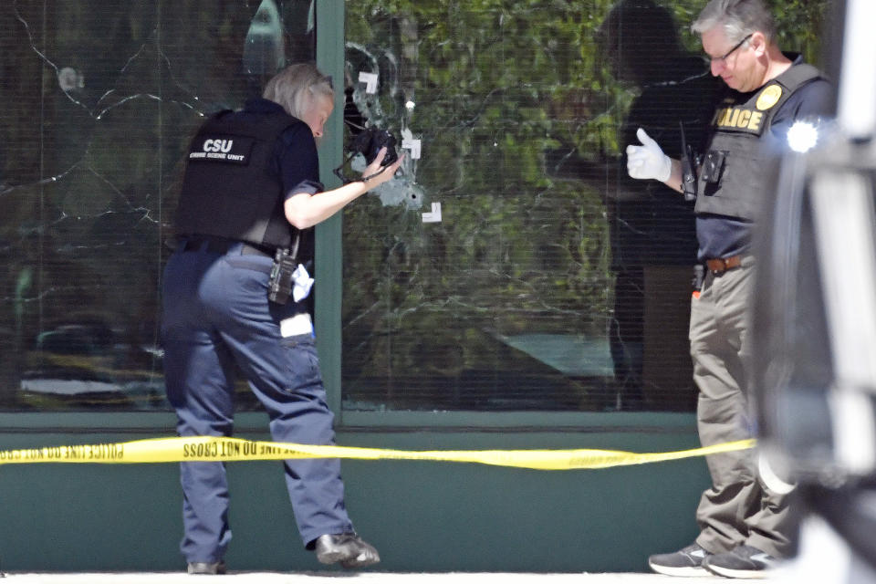 FILE - A Louisville Metro Police technician photographs bullet holes in the front glass of the Old National Bank building in Louisville, Ky., Monday, April 10, 2023, after a mass shooting. A 25-year-old bank employee armed with a rifle opened fire at his workplace, killing five people — including a close friend of Kentucky’s governor — while livestreaming the attack on Instagram, authorities said. Police arrived as shots were still being fired inside Old National Bank and killed the shooter during an exchange of gunfire. (AP Photo/Timothy D. Easley, File, File)