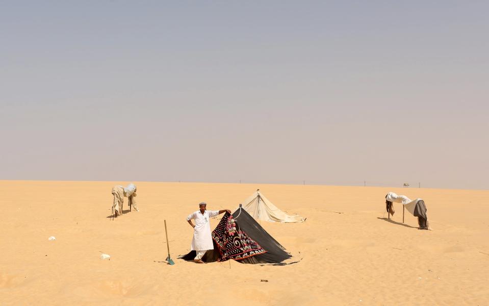 A worker waits near a tent after digging holes and erecting "sauna" tents for patients in Siwa, Egypt, August 11, 2015. (REUTERS/Asmaa Waguih)