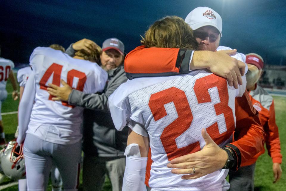 Morton coaches, including head coach Tim Brilley, facing at right, hug their players after the Potters' 41-14 loss to the Kankakee Kays in the Class 5A state football semifinals Saturday, Nov. 20, 2021 in Kankakee.