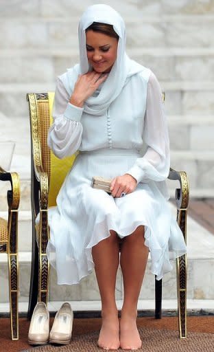 Britain's Prince William's wife, Catherine, the Duchess of Cambridge adjusts her scarf outside a mosque in Kuala Lumpur on September 14. The British royal family have warned an Italian magazine that "unjustifiable upset" would be heaped on Catherine if it went ahead and printed topless photos of her