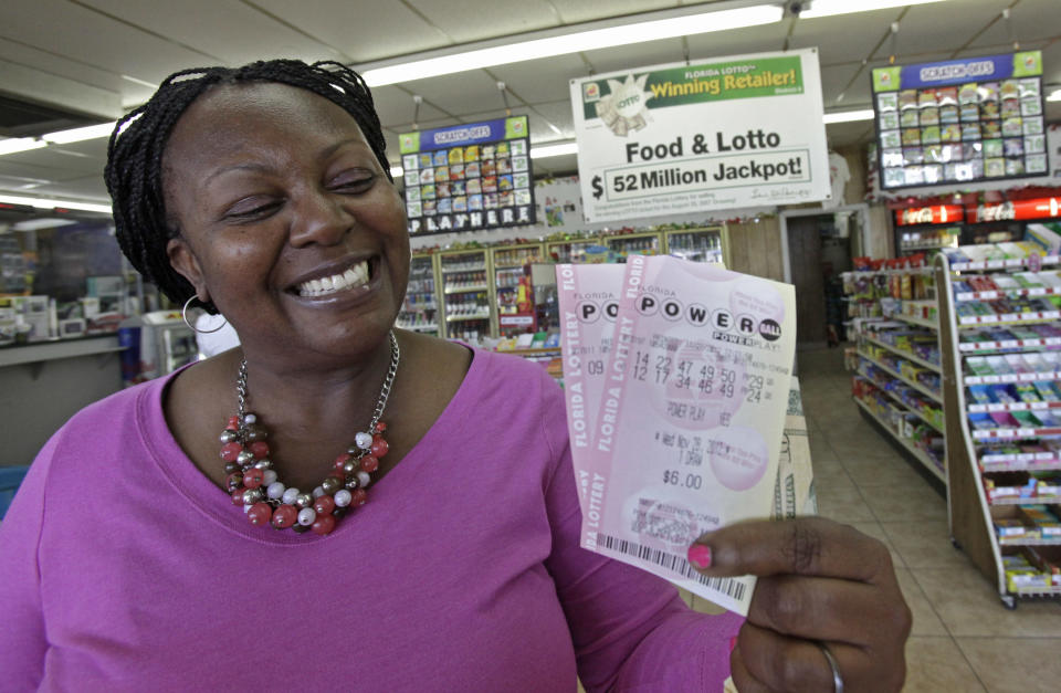 Felicia Ross shows off what she hopes will be the winning Powerball tickets at a convenience store, Tuesday, Nov. 27, 2012, in Orlando, Fla. The powerball jackpot is up over $500 million for Wednesday's drawing. (AP Photo/John Raoux)