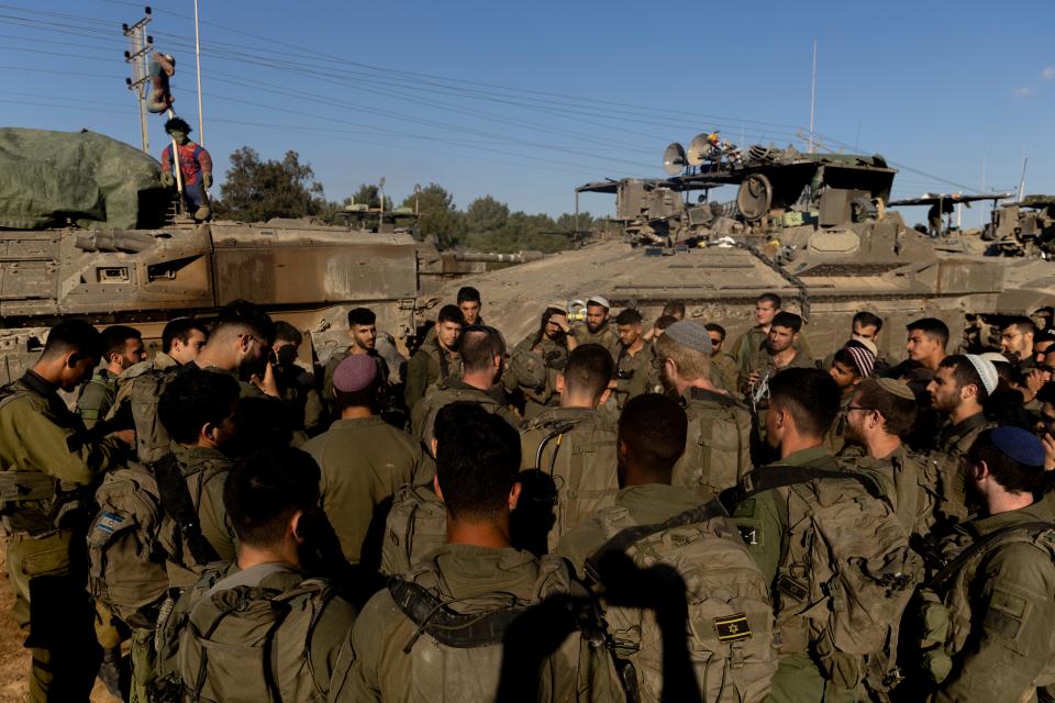 Israeli soldiers stand near tanks and armored personnel carrier near the border with the Gaza Strip on April 10, 2024, in Southern Israel.