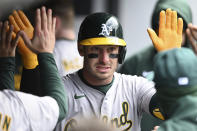 Oakland Athletics' Brent Rooker celebrates with teammates after hitting a solo home run off Cleveland Guardians starting pitcher Tanner Bibee during the fourth inning of a baseball game, Sunday, April 21, 2024, in Cleveland. (AP Photo/Nick Cammett)