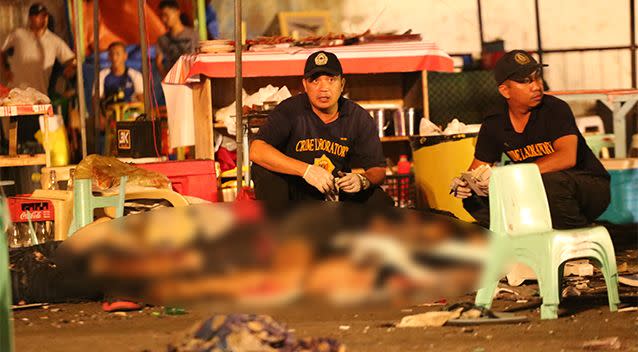 Philippine police investigators check bodies at a blast site at a night market on September 2. Photo: AP