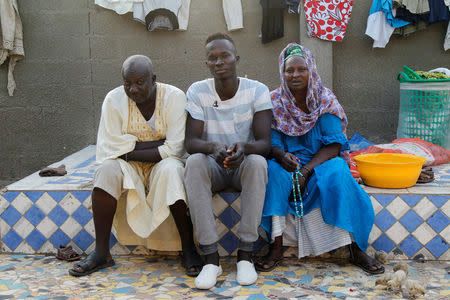 Buba Fubareh (C), a Gambian migrant who voluntarily returned from Libya, sits with relatives at his home in Brikama, Gambia April 6, 2017. REUTERS/Luc Gnago