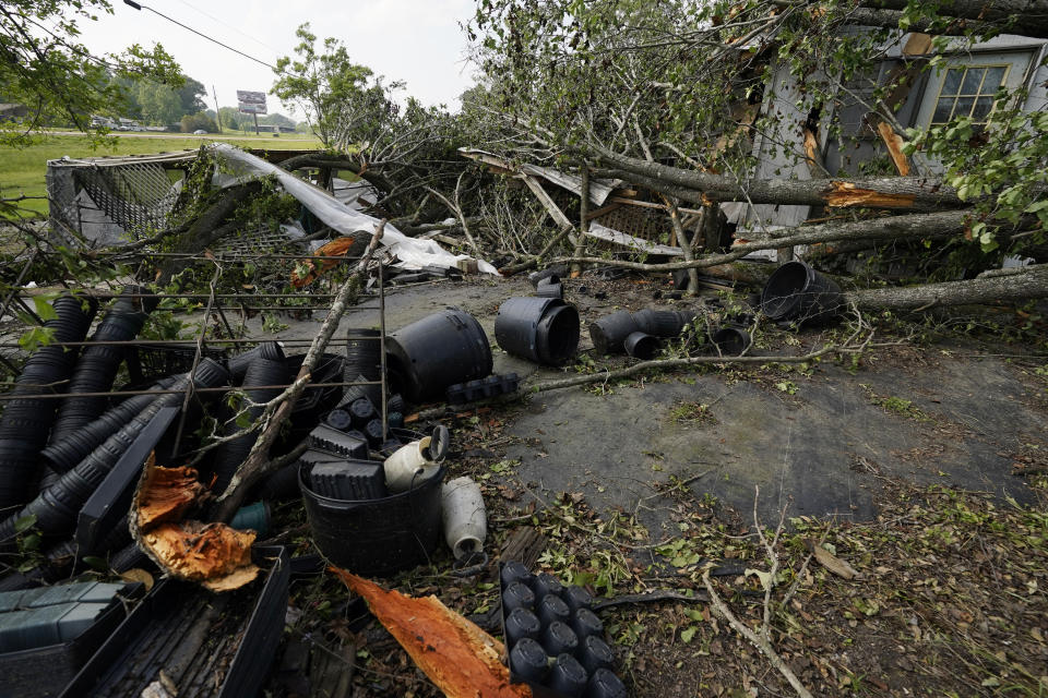 Scattered pots and fallen tree limbs are seen strewn by the winds of Sunday's tornado, by what's left of Poore's Nursery in Yazoo County, Miss., Monday, May 3, 2021. The building and the owners' home were heavily damaged from the fallen limbs, many that had yet to be removed from the property by Monday afternoon. (AP Photo/Rogelio V. Solis)