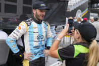 Agustin Canapino, left, of Argentina, records a video during practice for the Indianapolis 500 auto race at Indianapolis Motor Speedway in Indianapolis, Friday, May 19, 2023. (AP Photo/Michael Conroy)