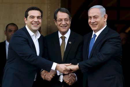 Cypriot President Nicos Anastasiades (C), Israeli Prime Minister Benjamin Netanyahu (R) and Greek Prime Minister Alexis Tsipras shake hands outside the presidential palace in Nicosia, Cyprus, in this January 28, 2016 file picture. REUTERS/Yiannis Kourtoglou/Files