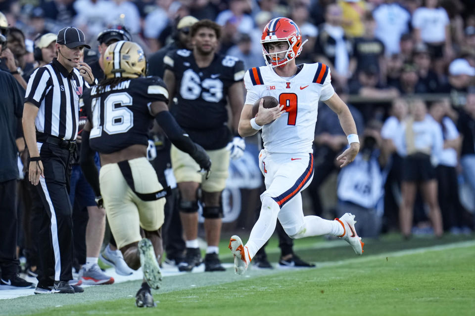 Illinois quarterback Luke Altmyer (9) runs out of bounds in front of Purdue defensive back Marquis Wilson (16) during the second half of an NCAA college football game in West Lafayette, Ind., Saturday, Sept. 30, 2023. (AP Photo/Michael Conroy)