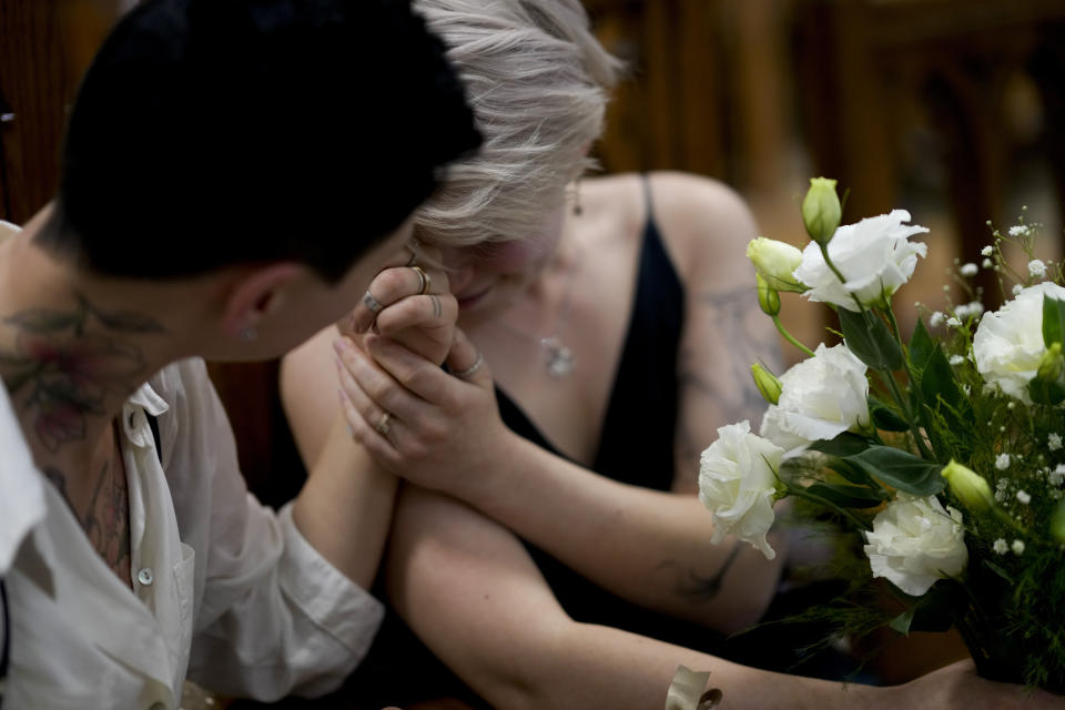 Newlyweds Tatiana Skvortosova, left, and Nadezhda Skvortosova, both Russian nationals, react as a judge declares them wives at a civil registry in Buenos Aires, Argentina, Friday, April 28, 2023. In December 2022, Russian President Vladimir Putin signed a law that significantly expanded restrictions on activities seen as promoting LGBTQ+ rights in the country, building on a law that had been in place since 2013 and that independent researchers say led to a surge in violence against sexual minorities. (AP Photo/Natacha Pisarenko)