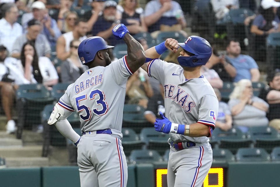 Texas Rangers' Adolis Garcia (53) greets Josh Jung at home after Jung's home run off Chicago White Sox starting pitcher Tanner Banks during the third inning of a baseball game Monday, June 19, 2023, in Chicago. (AP Photo/Charles Rex Arbogast)
