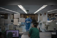 Healthcare workers assist COVID-19 patients at a library that was turned into an intensive care unit (ICU) at Germans Trias i Pujol hospital in Badalona, Barcelona province, Spain, Wednesday, April 1, 2020. The new coronavirus causes mild or moderate symptoms for most people, but for some, especially older adults and people with existing health problems, it can cause more severe illness or death. (AP Photo/Felipe Dana)