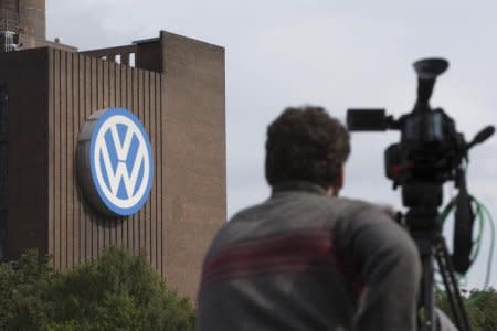 A journalist stands in front of the Volkswagen powerplant in Wolfsburg, Germany September 23, 2015. REUTERS/Axel Schmidt