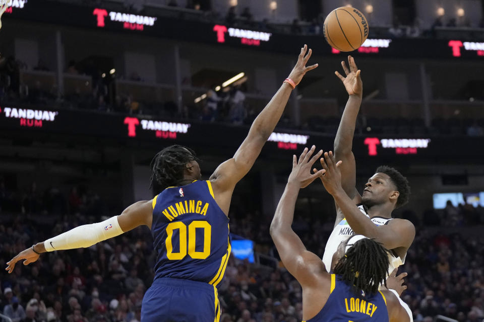 Minnesota Timberwolves guard Anthony Edwards, top right, shoots against Golden State Warriors forward Jonathan Kuminga (00) and forward Kevon Looney during the first half of an NBA basketball game in San Francisco, Sunday, Feb. 26, 2023. (AP Photo/Jeff Chiu)