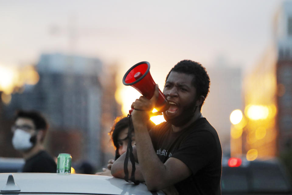 A protest leader chants with demonstrators Sunday, May 31, 2020, after curfew in Minneapolis. Protests continued following the death of George Floyd, who died after being restrained by Minneapolis police officers on Memorial Day. (AP Photo/Julio Cortez)