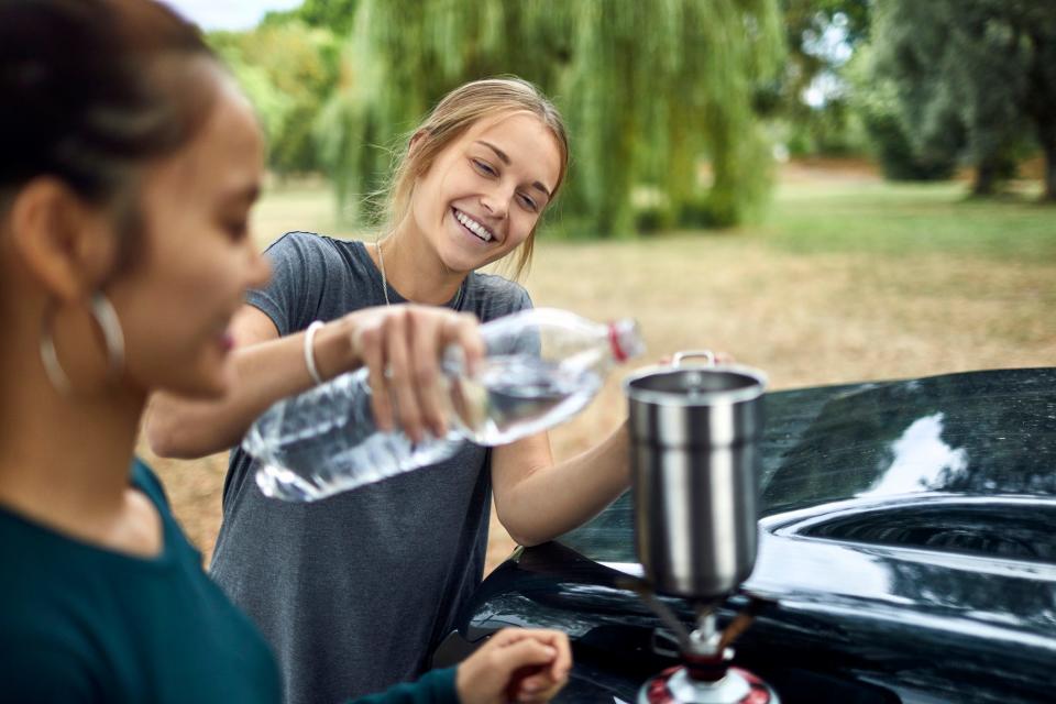 A woman boiling bottled water.