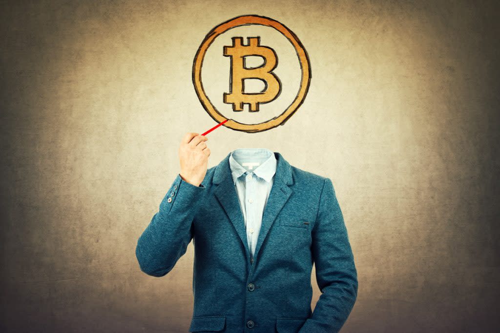 A man in a business suit draw the B in bitcoin over her face. 
