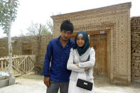 In this photo released by Nursimangul Abdureshid, Memetali Abdureshid poses for a picture with his sister Nursimangul Abdureshid outside their family home in Sayibage township in China's far west Xinjiang region in August 2013. Nearly one in 25 people in a county in the Uyghur heartland of China has been sentenced to prison on terrorism-related charges, in what is the highest known imprisonment rate in the world, an Associated Press review of leaked data shows. Memetali Abdureshid, who ran a car repair shop, was listed as being sentenced to 15 years and 11 months in prison on charges of "picking quarrels and provoking trouble” and “preparing to carry out terrorist activities." (Nursimangul Abdureshid via AP)