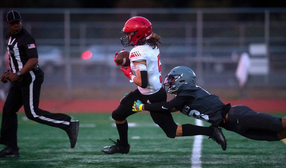 Yelm wide receiver Kyler Ronquillo pulls in a pass in front of River Ridge defensive back Jerrell Larkins during Friday night’s high school football game at South Sound Stadium in Lacey, Washington, on Sept. 24, 2021.