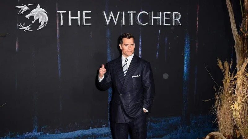 Henry Cavill stands successful  beforehand   of a motion   for The Witcher astatine  a reddish  carpet event. 